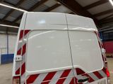 a white van with red and white stripes parked in a garage