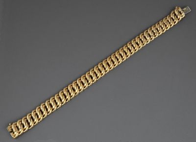 a close up of a gold chain bracelet on a gray surface