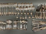 many forks and spoons laid out on the table