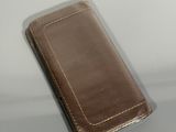 a brown wallet sitting on top of a white table
