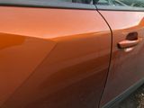 an orange car that is parked on the side of the road
