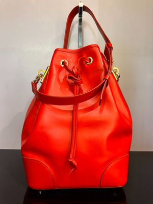 un sac seau rouge posé sur une table noire près d'un mur blanc