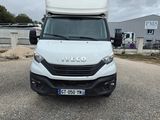 La camionnette blanche est garée sur le parking près d'un immeuble.