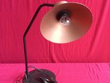 a lamp that is sitting on a table with a pink background
