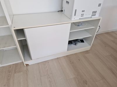 une armoire blanche sur laquelle est posé un micro-ondes