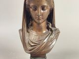 un buste en bronze représentant une femme portant un voile sur la tête