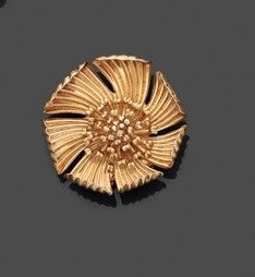 broche en forme de fleur plaquée or sur un fond noir