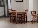 a table and chairs in a room with white walls