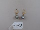 deux paires de boucles d'oreilles et une étiquette de prix posées sur une table