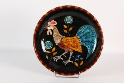 une photo d'une assiette décorative sur laquelle figure un coq