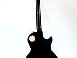 an image of a black electric guitar on a stand against a white background