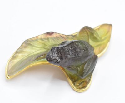 a leaf shaped brooch with a frog on it ' s back