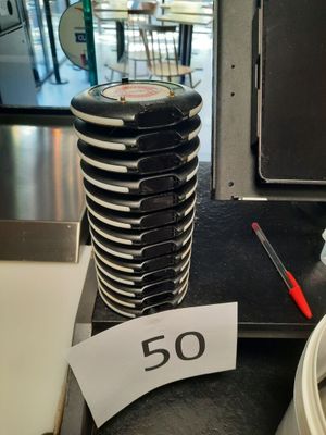une pile d'assiettes posée sur une table, avec une pancarte indiquant « 50 »