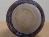 a close up of a blue and white vase on a table