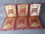 quatre couvertures de livres rouges et dorées, ornées de dorures à chaud
