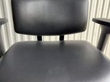 an office chair with black leather upholstered seat and casteors