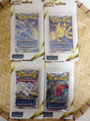 four packs of pokemon cards sitting on top of a wooden tray