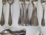 many spoons, forks, and spoon spoons laid out on a table
