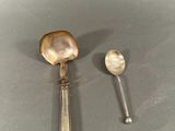two spoons and a spoon rest on a gray surface