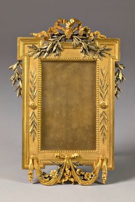 an antique gold picture frame with leaves and flowers on a gray background