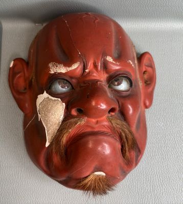 un masque rouge accroché au mur d'une pièce