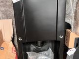 une boîte noire recouverte d'un sac en plastique, posée à côté d'une pile de boîtes