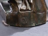 a bronze statue of a man and a woman sitting on a rock