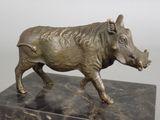 a bronze statue of a boar on a marble base