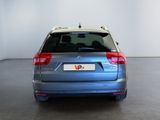 the rear of a blue car is parked in a white room