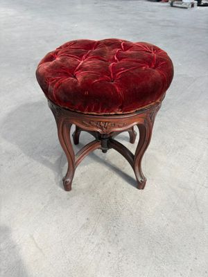 tabouret rembourré en velours rouge avec des pieds en bois