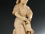 l'image d'une statue de femme assise sur un rocher