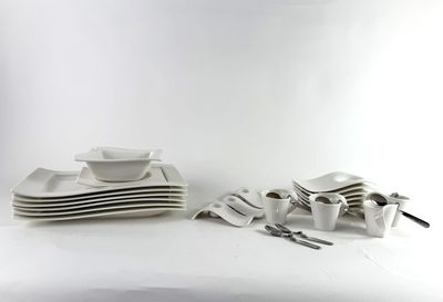 a lot of white plates and bowls on the table