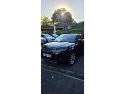 une voiture noire garée dans un parking à côté d'autres voitures