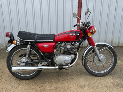une moto rouge garée devant un immeuble
