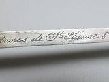 a silver spoon with writing on it sitting on a table