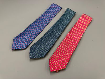 three different colored ties sitting on top of a table