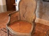 a wicker chair in front of a fireplace in a living room