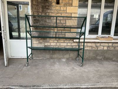 a green metal frame with a basket on top of it