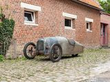 an old car parked in front of a brick building