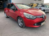 une voiture rouge garée dans un parking à côté d'autres voitures