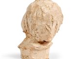 sculpture of a woman ' s head made of clay on a white surface