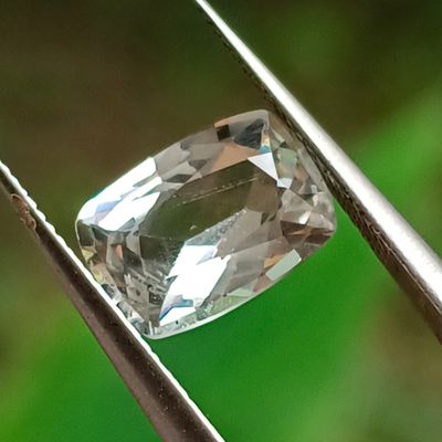 un gros plan d'un diamant tenu par une pince