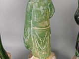 three green and white ceramic figurines of a man and a woman