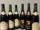 six bouteilles de vin sont alignées sur une table