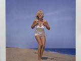 photograph of a woman in a white bathing suit on a beach
