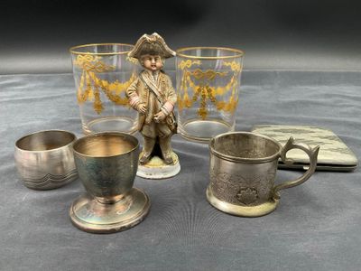 trois tasses et une figurine représentant un homme assis sur une table