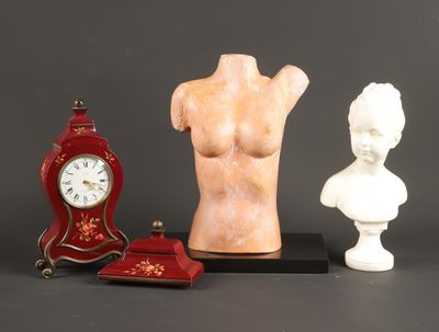 trois statues et une horloge posées sur une table