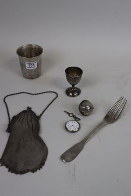 a table with silverware, a fork, a cup, and a spoon on it
