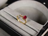 une bague en or sertie d'une pierre rouge, dans une boîte