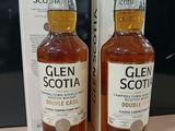 deux bouteilles de whisky Glen posées sur une table à côté d'une boîte